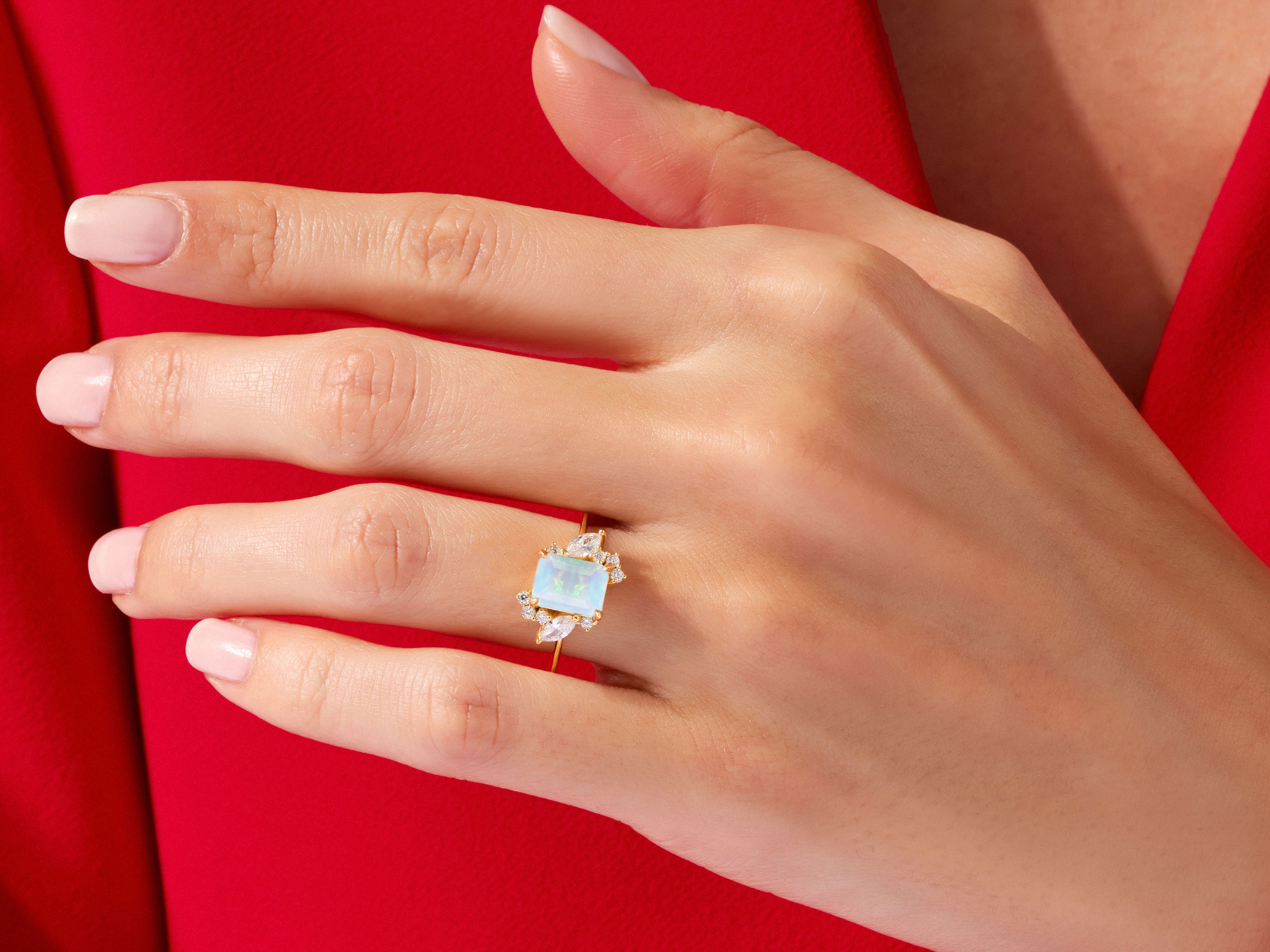 Gold ring with opal and diamonds on a hand