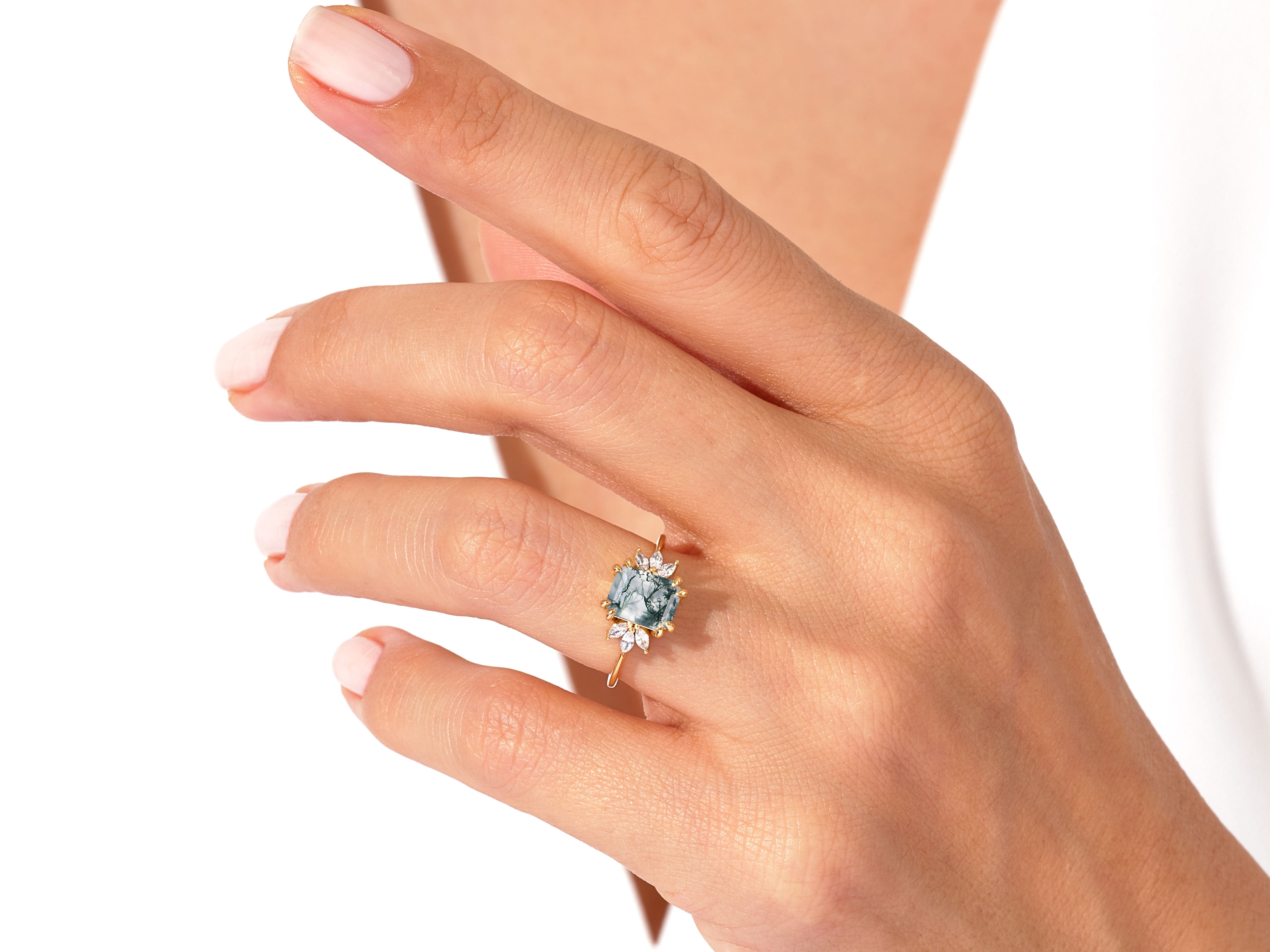 Gold ring with moss agate and diamonds on a hand