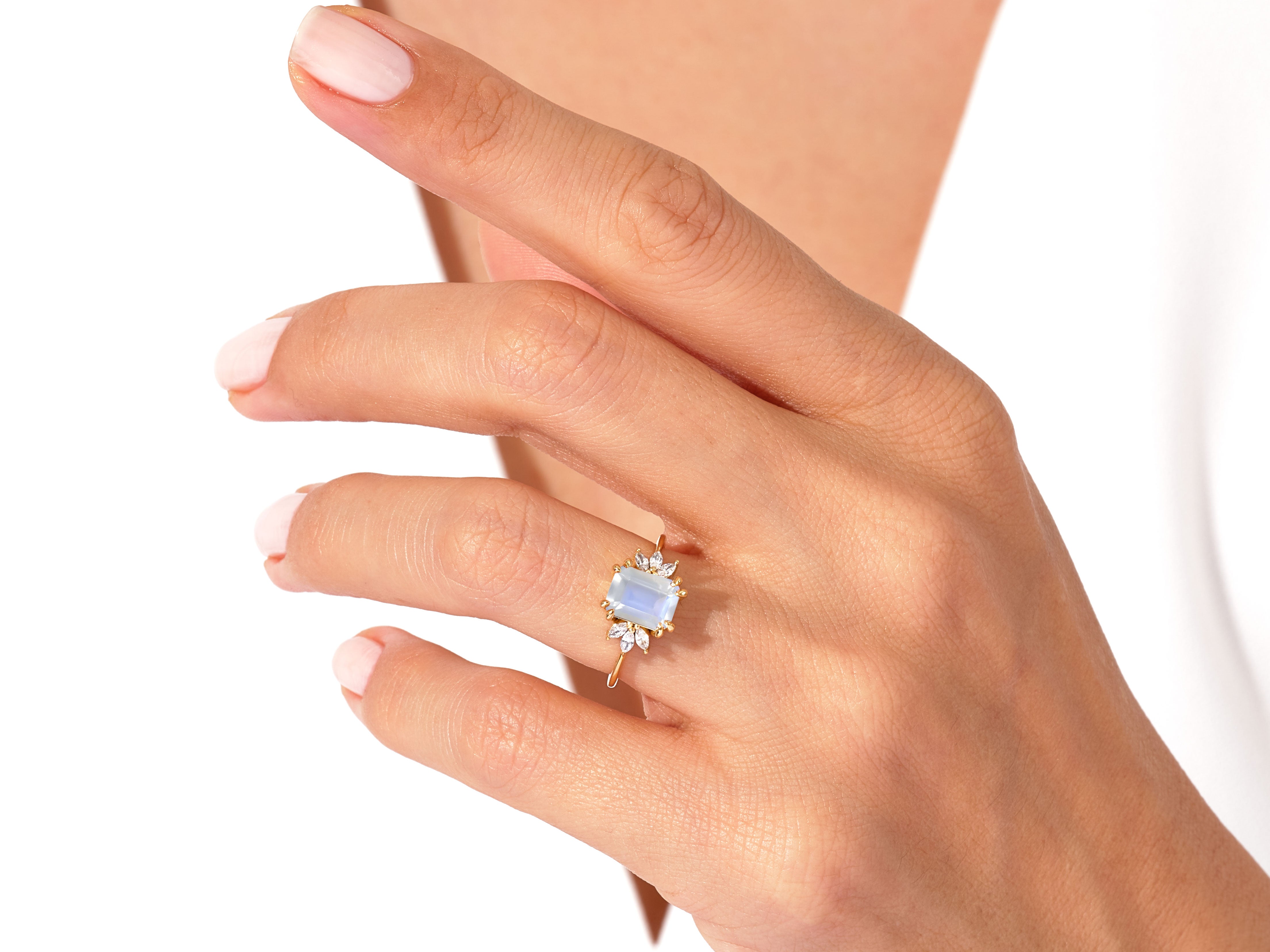 Gold ring with moonstone and diamonds on a woman's hand