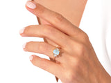 Gold ring with opal and diamonds on a woman's hand