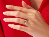 Gold ring with blue gemstone and diamonds on a hand