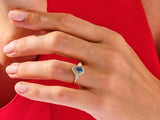 Gold ring with blue sapphire and diamonds on a hand