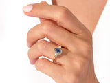 Gold ring with blue heart-shaped gemstone and diamonds on hand