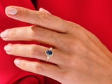 Gold ring with blue gemstone and diamonds on hand