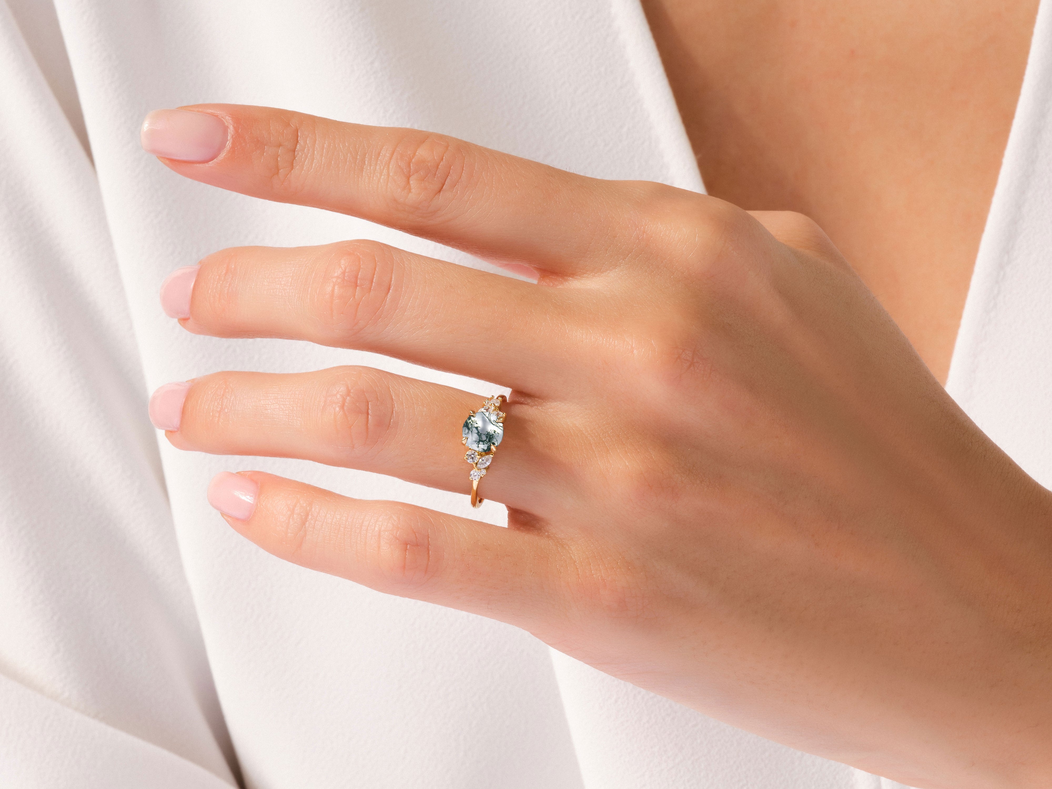 Gold ring with blue gemstone and diamonds on a hand
