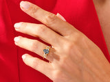Gold ring with black gemstone and diamonds on a hand