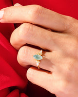 Gold ring with green gemstone and diamonds on a hand