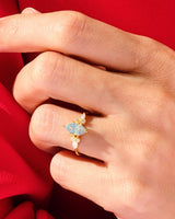 Gold opal marquise ring with diamonds on red silk