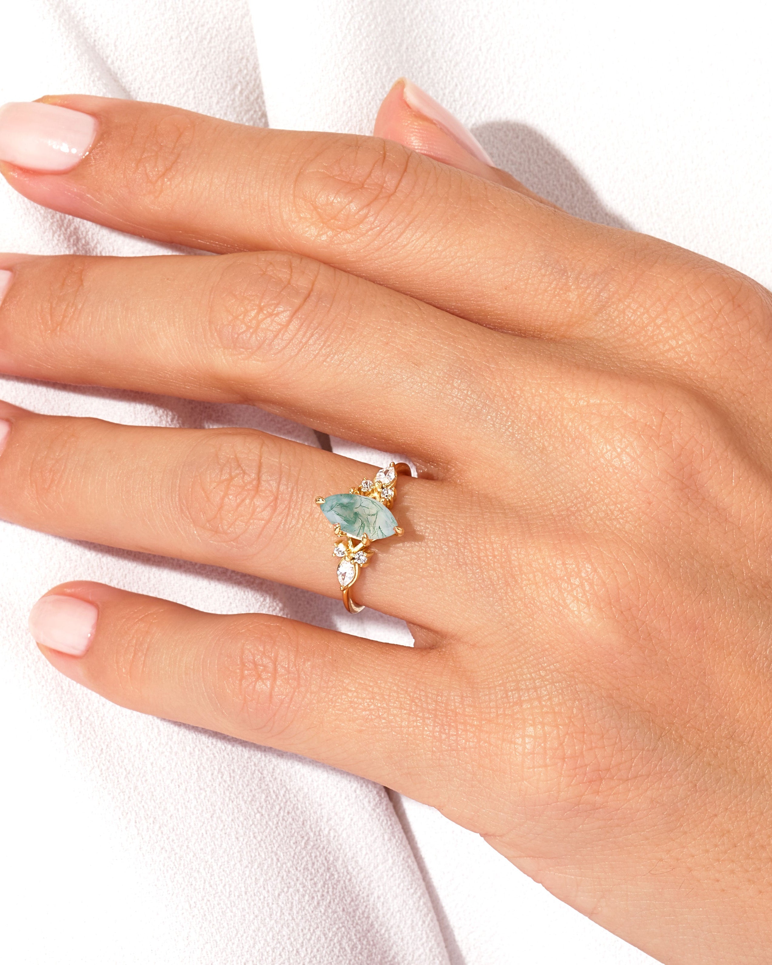Gold ring with marquise moss agate and diamond accents on hand