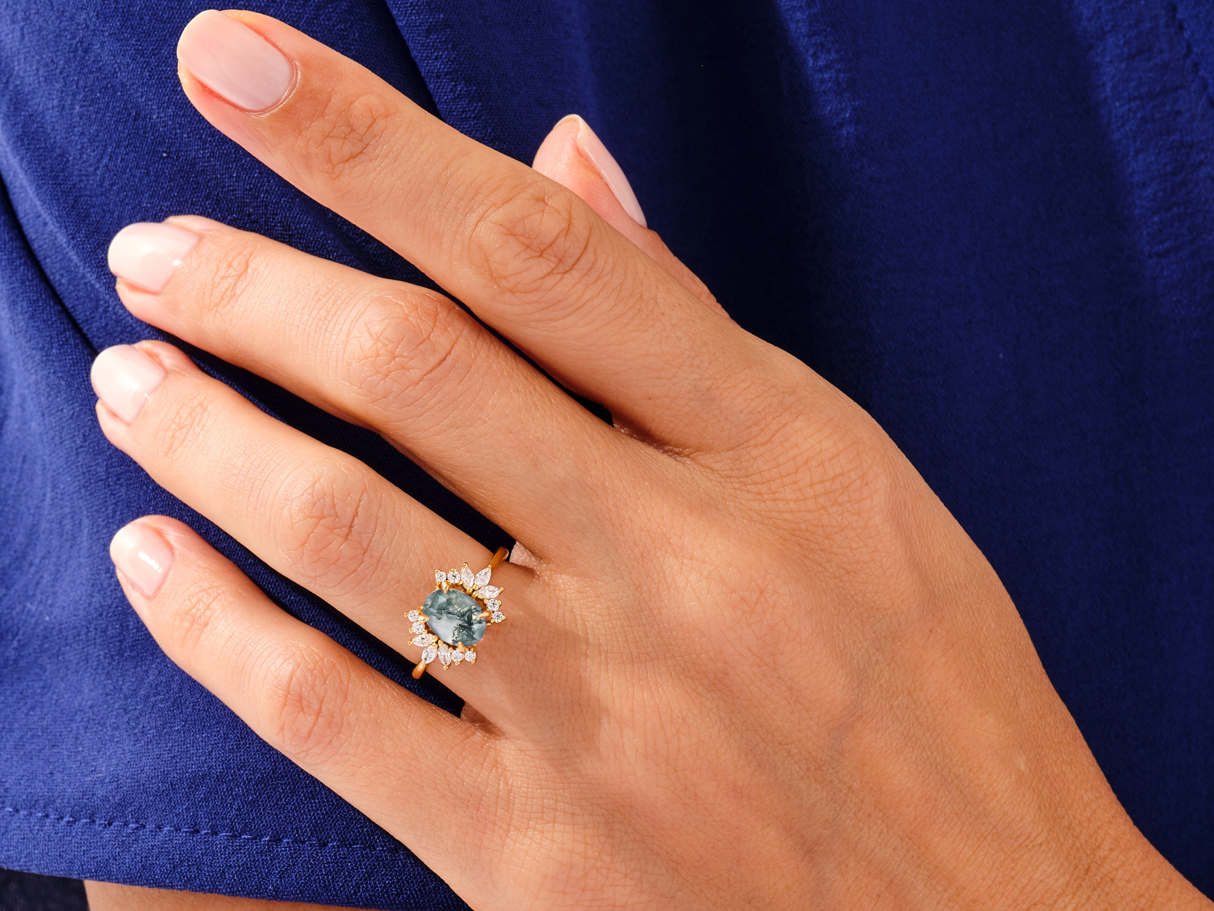 Gold ring with moss agate and diamonds on a hand