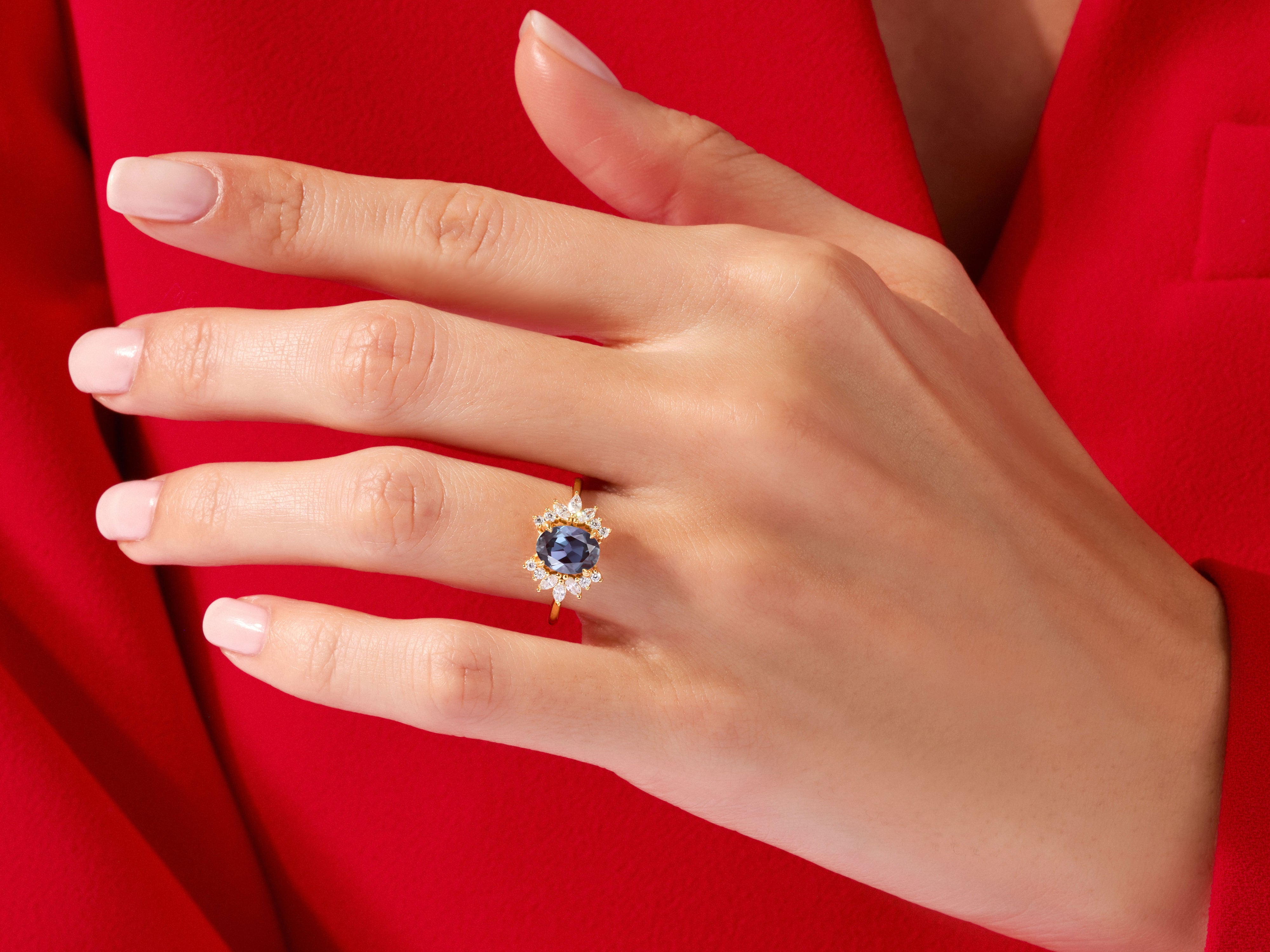 Oval sapphire and diamond halo ring on a hand