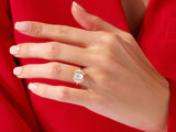 Gold ring with oval moonstone and diamond halo on a hand