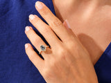 Gold ring with black stone and diamonds on a hand
