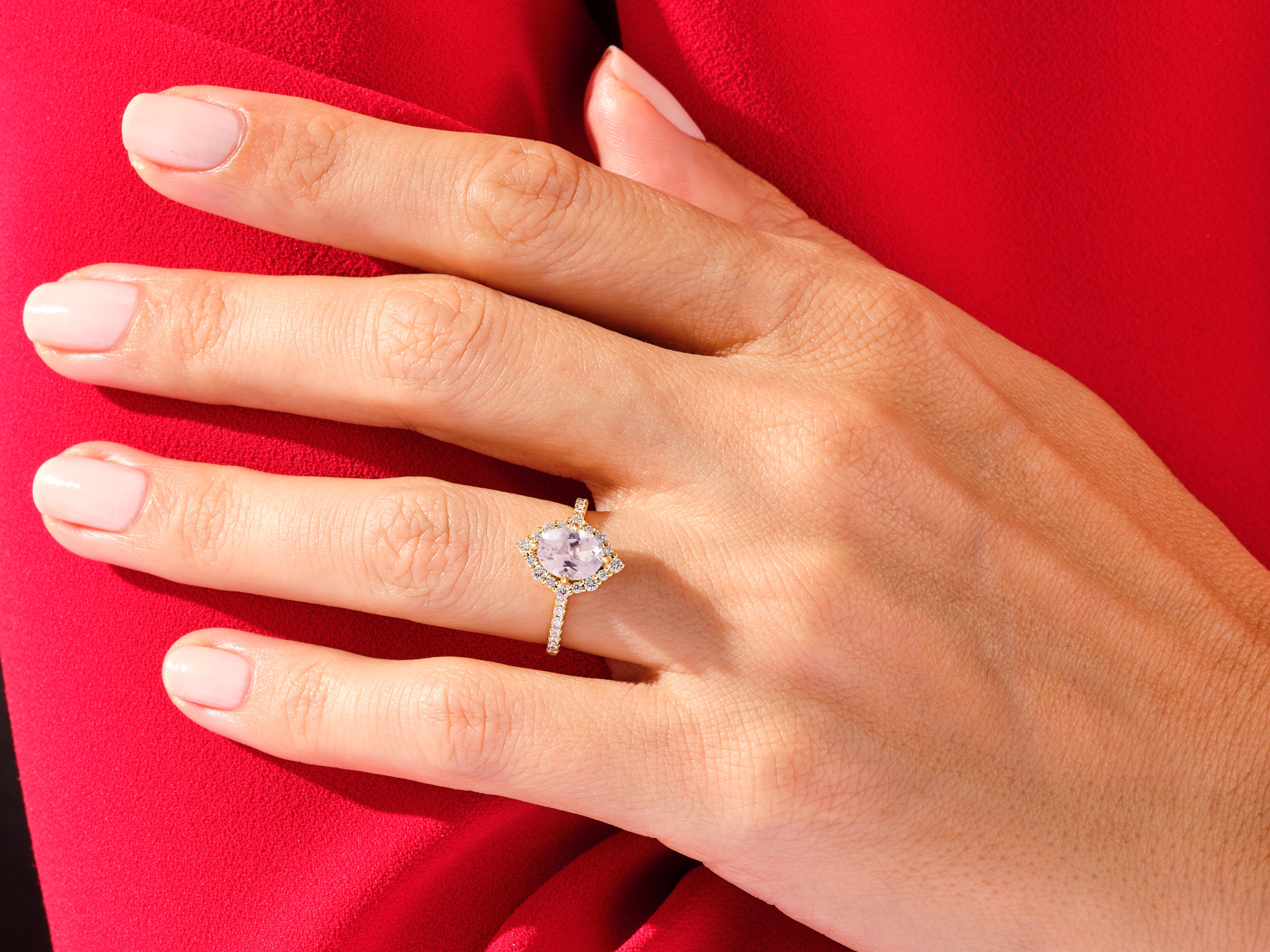 Diamond halo engagement ring with pink gemstone on hand