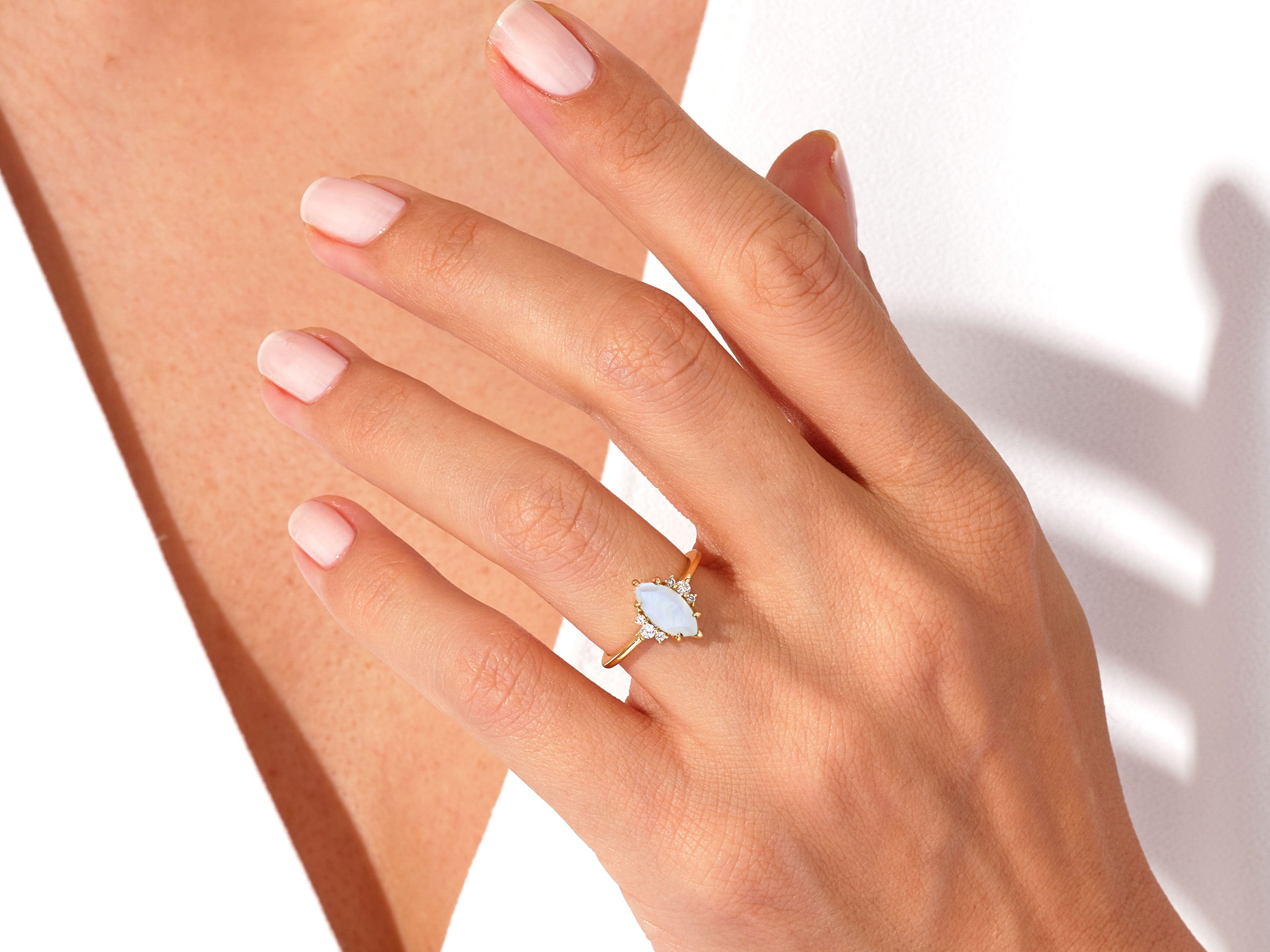 Gold marquise opal ring with diamonds on hand
