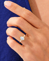 Gold ring with blue gemstone and diamonds on a woman's hand