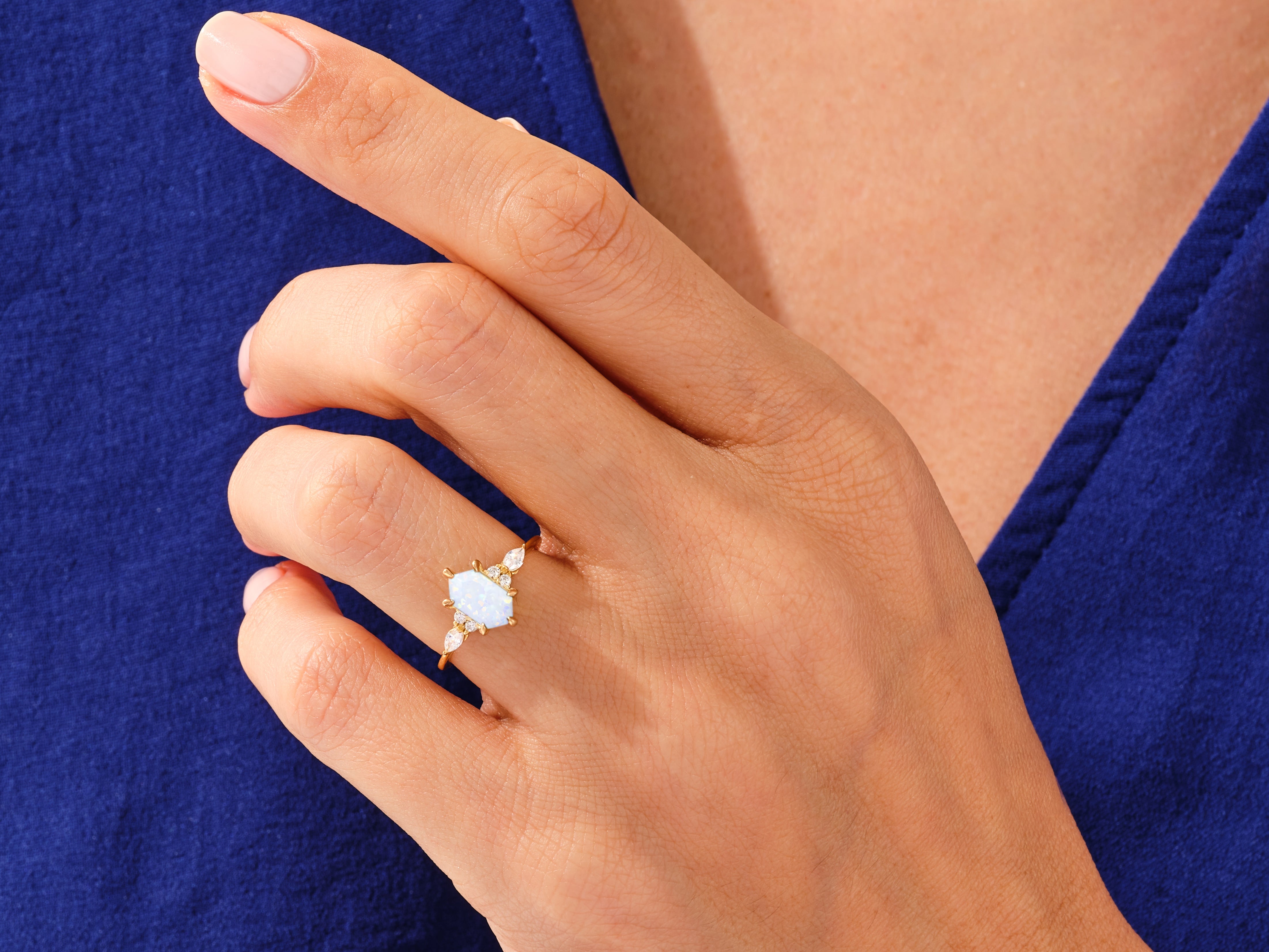 Gold opal ring with diamonds on a woman's hand