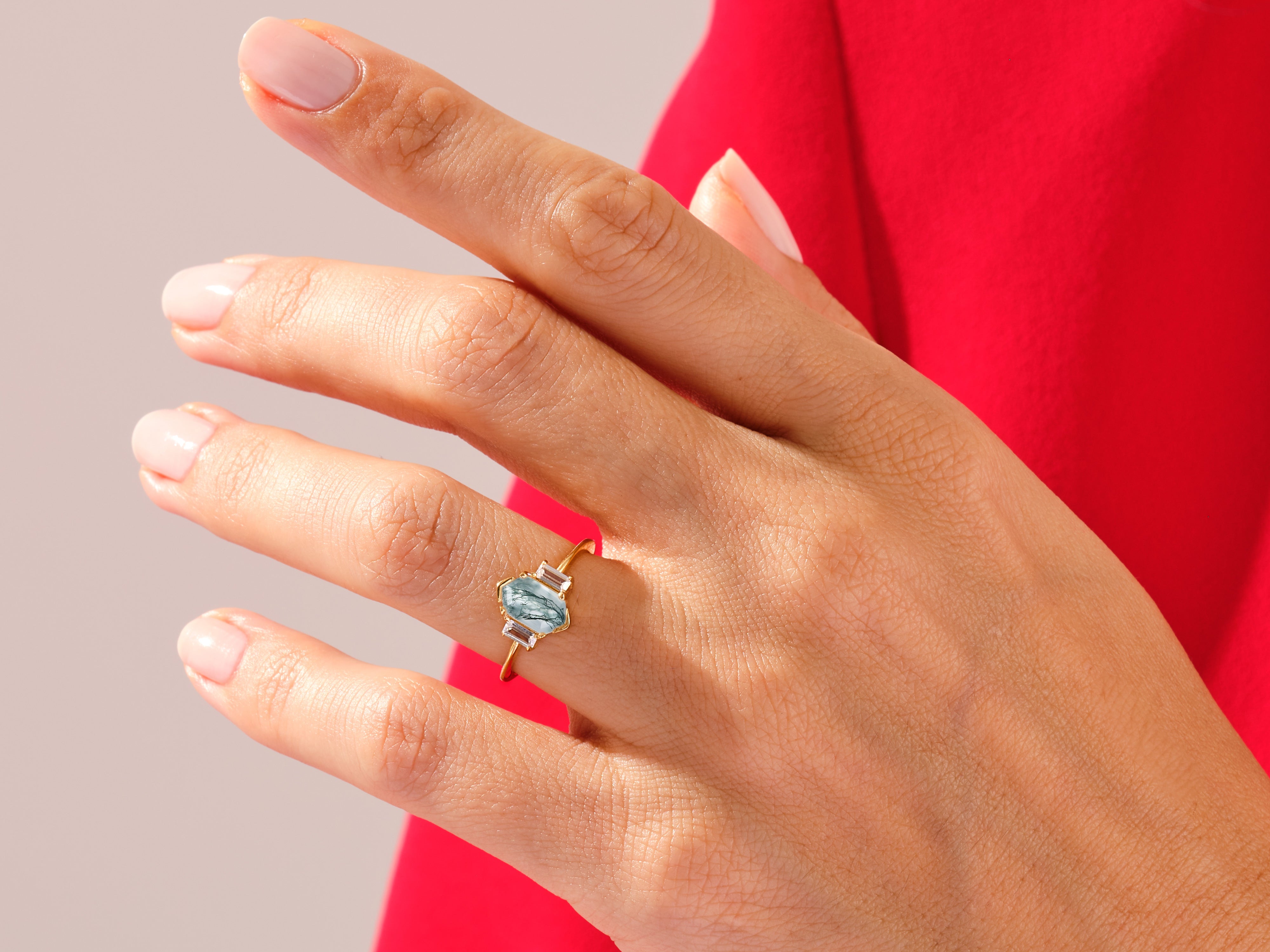 Gold ring with unique gemstone and diamond accents on hand