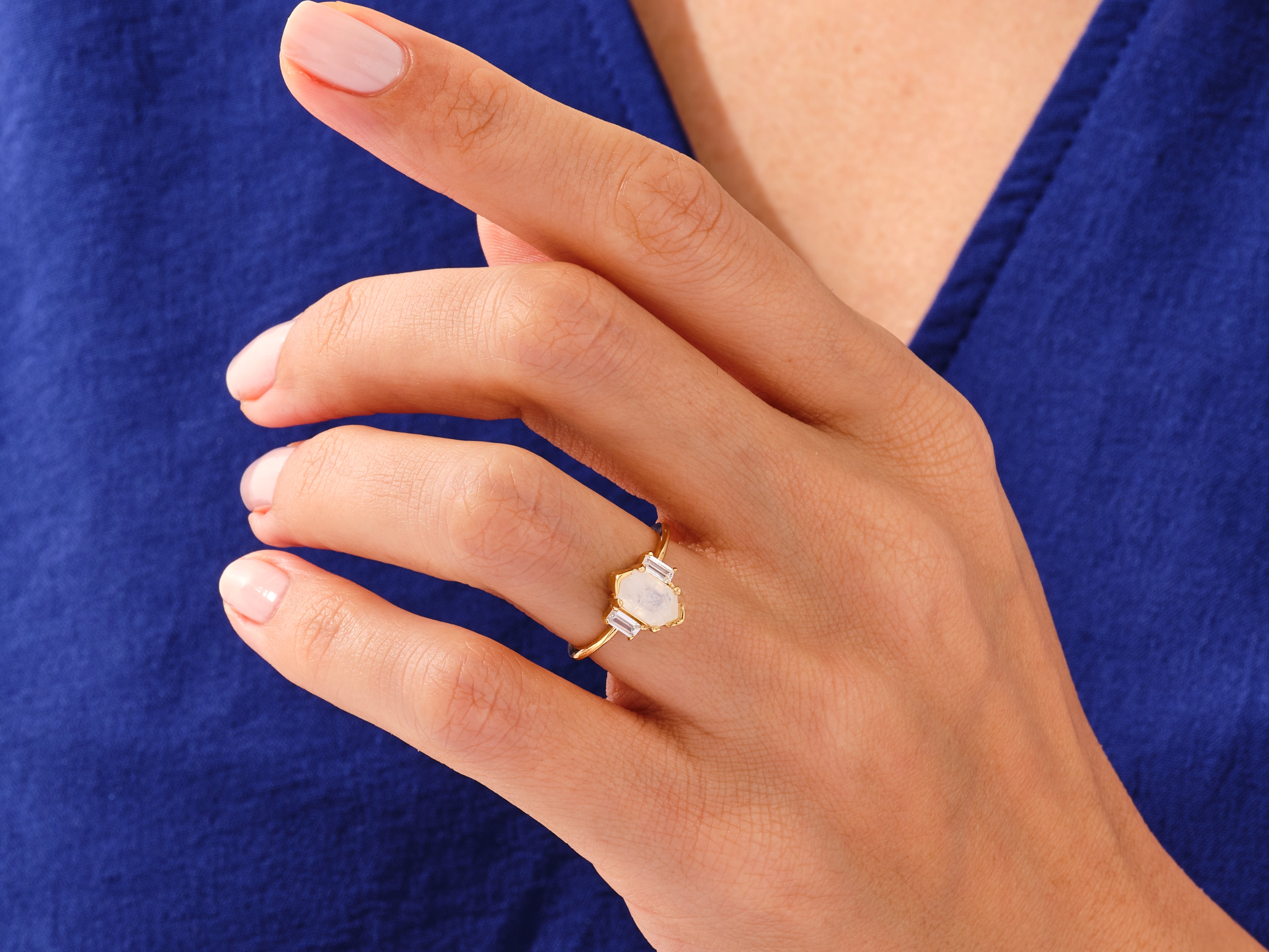 Gold ring with moonstone and baguette diamonds on hand