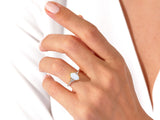 Gold opal ring with diamonds on a hand