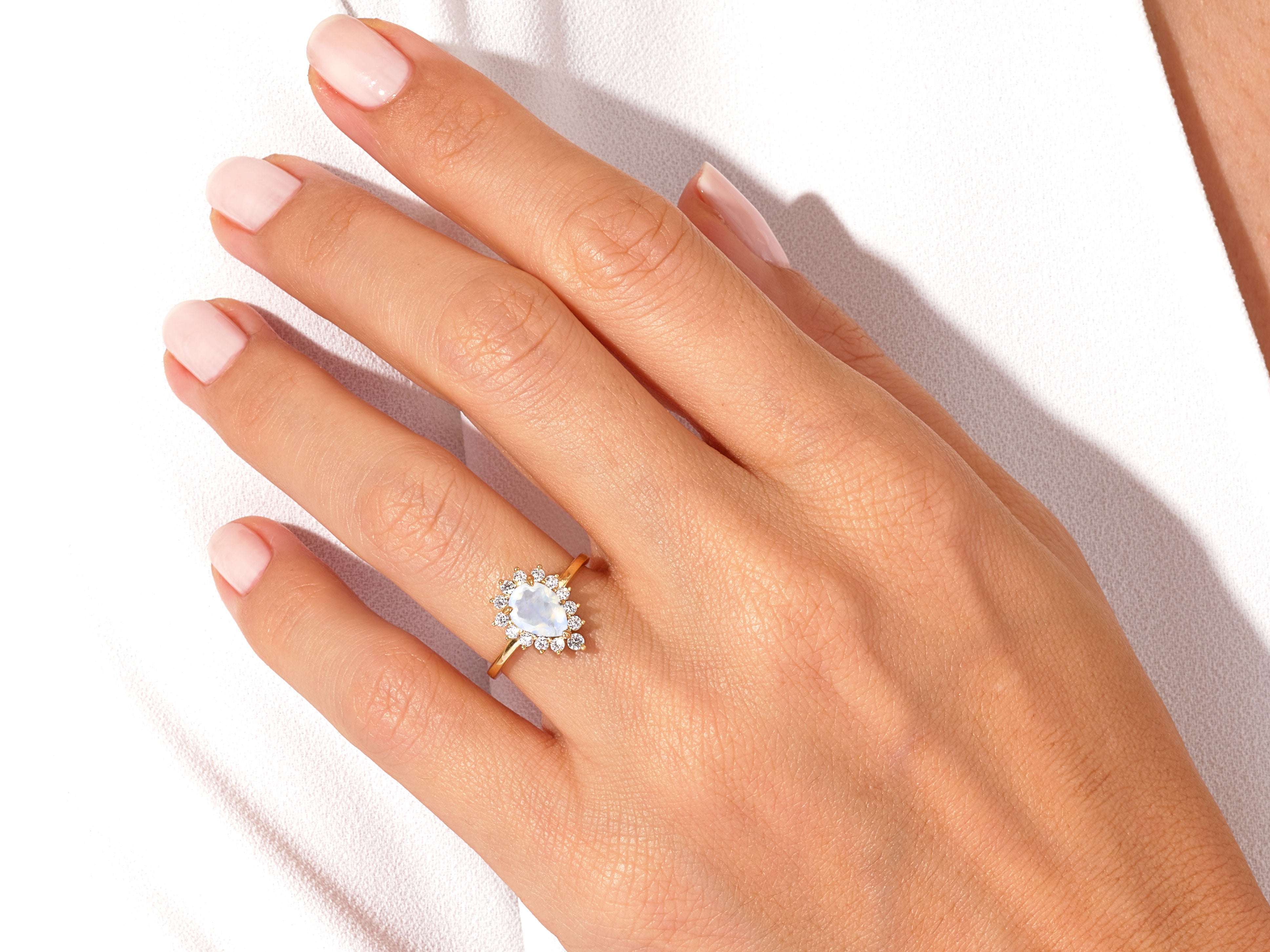 Gold ring with moonstone and diamonds on a hand