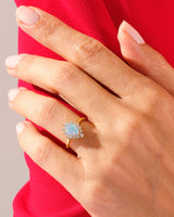 Gold opal diamond halo ring on hand