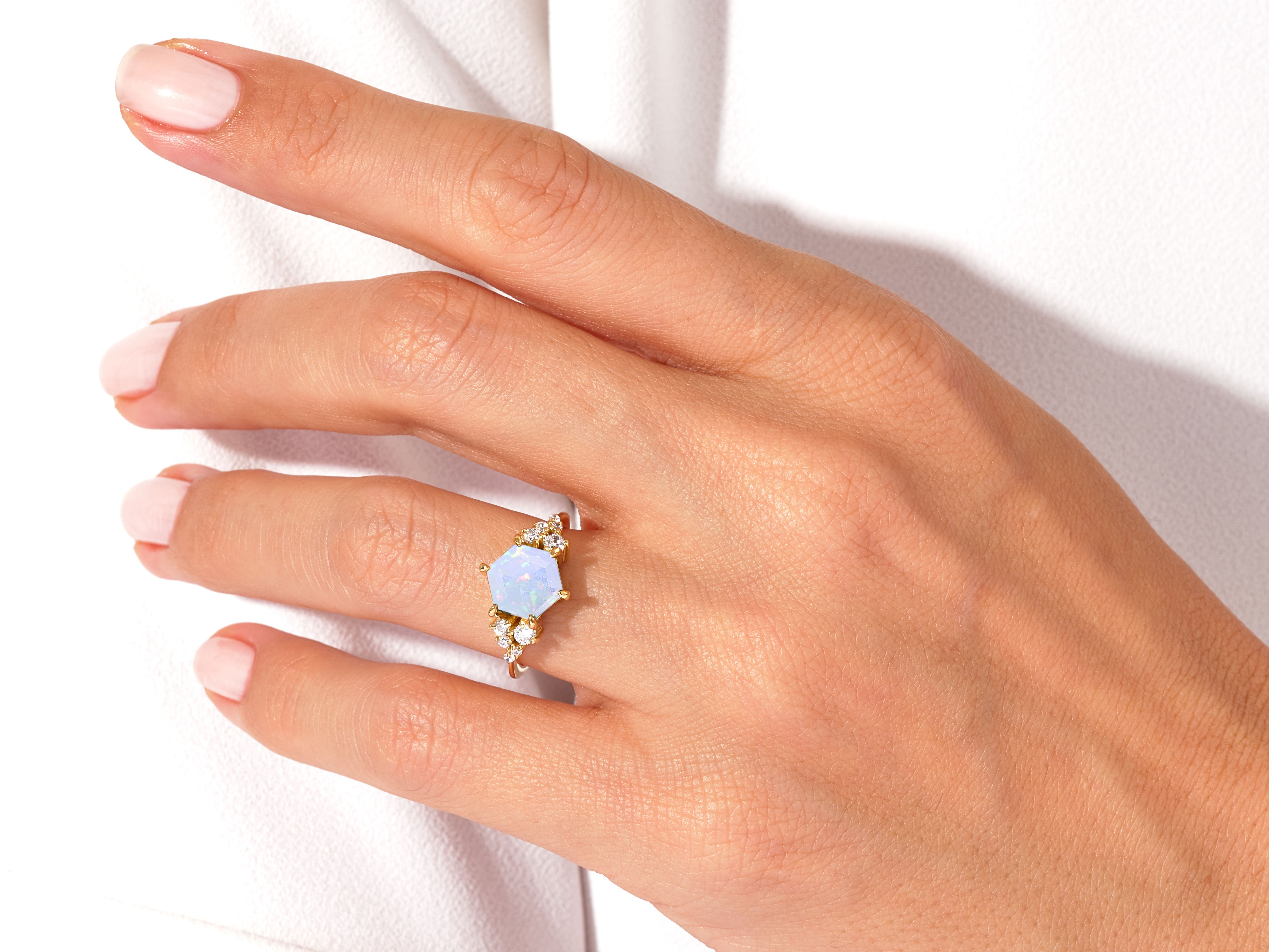 Gold opal hexagon ring with diamonds on hand