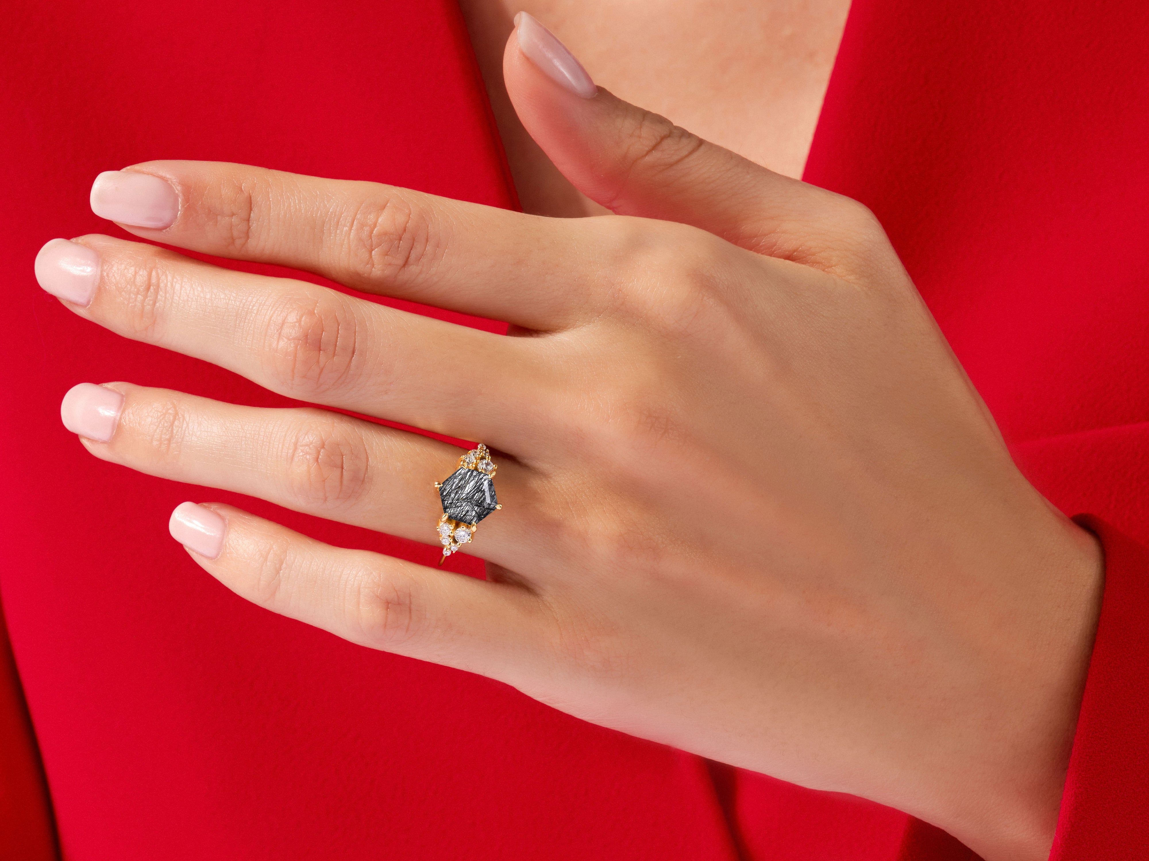 Hexagonal black rutile quartz ring with diamonds on a red background
