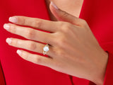 Hexagonal gemstone ring with diamonds on a red background