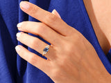 Gold ring with blue sapphire and diamonds on a hand