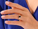Gold ring with black stone and diamonds on a hand