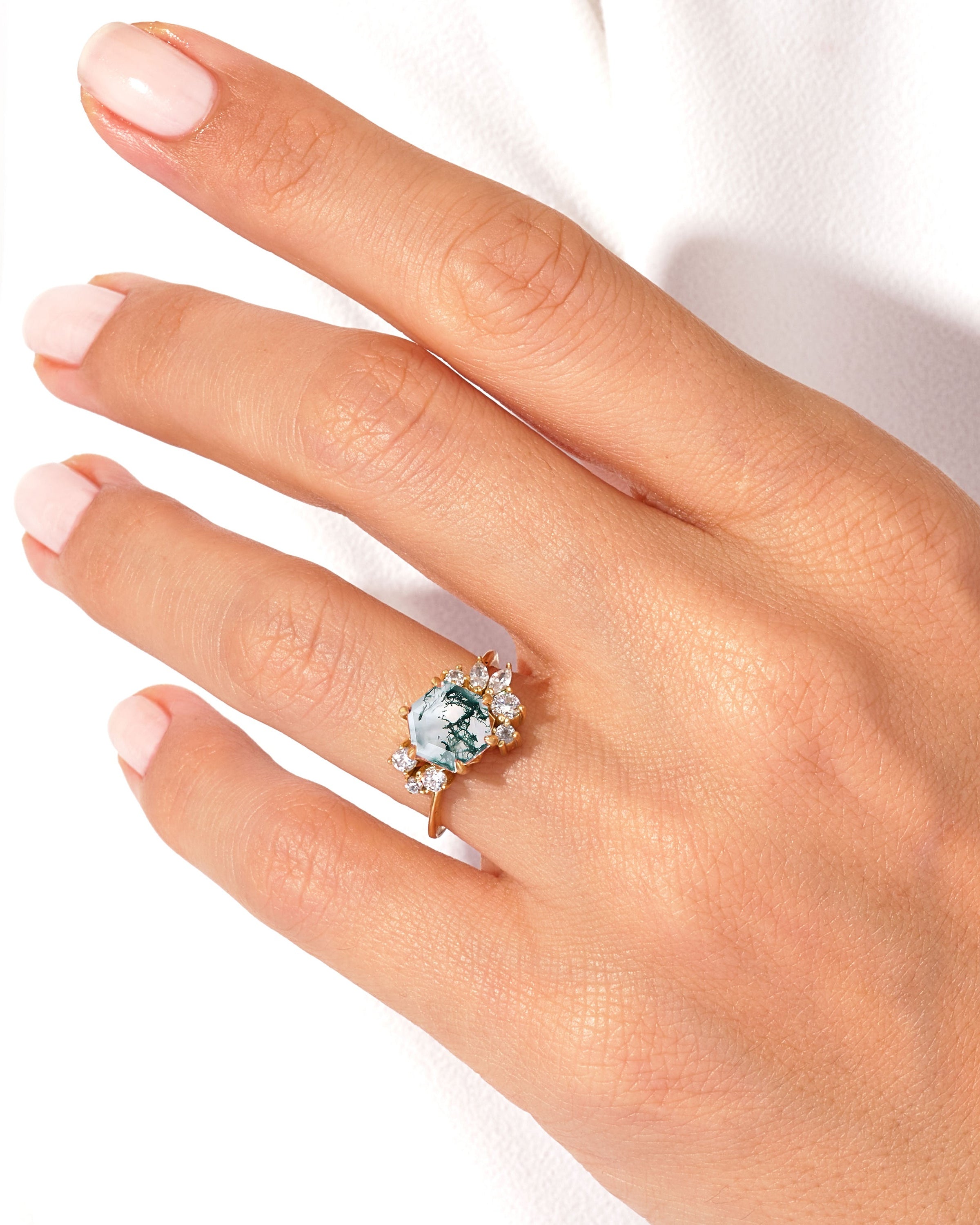 Moss agate engagement ring with diamonds on a hand