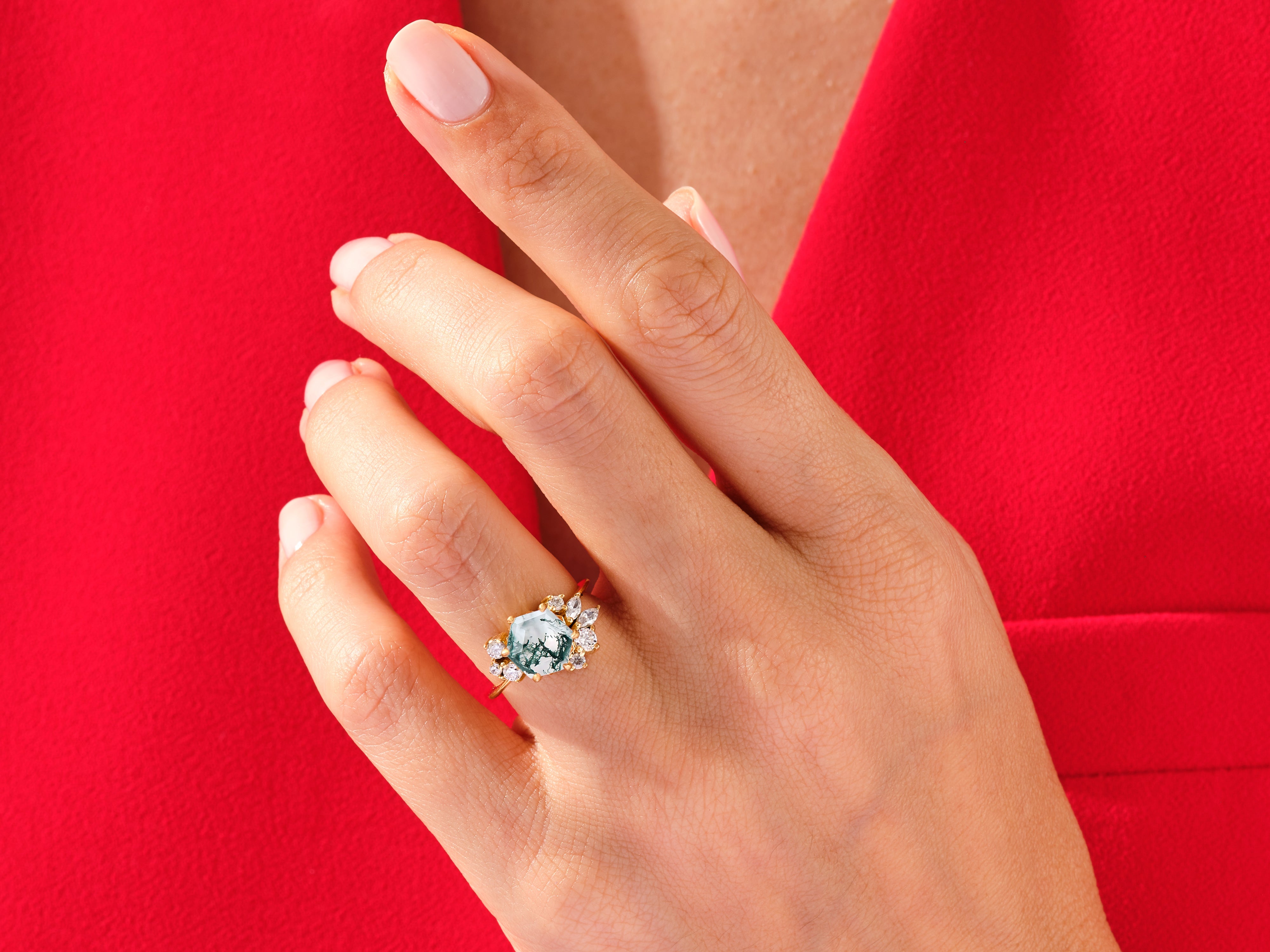 Moss agate ring with diamonds on a hand
