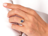 Oval sapphire and diamond engagement ring on hand