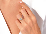 Gold ring with blue gemstone and diamonds on a woman's hand