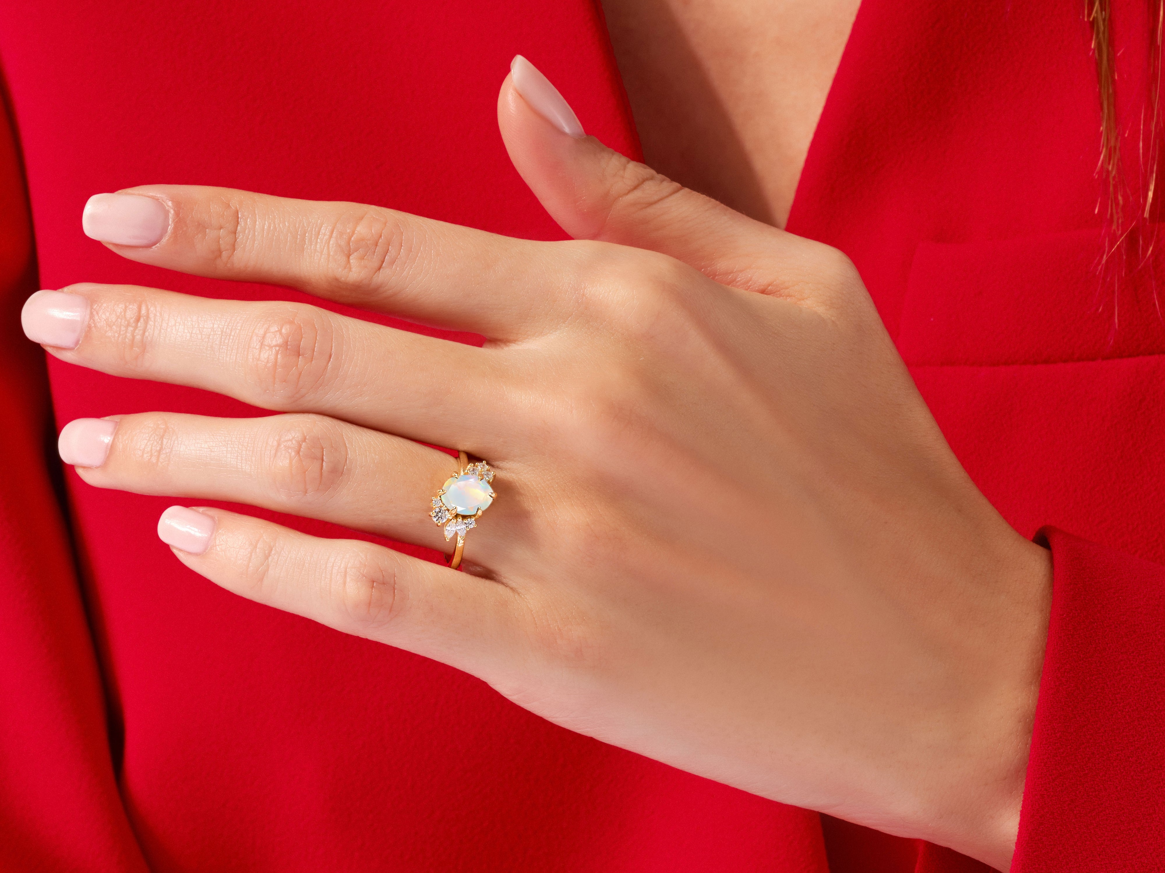 Gold opal ring with diamonds on a hand