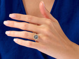 Hexagonal gemstone ring with diamonds on a woman's hand