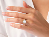 Hexagonal gemstone ring with diamonds on a woman's hand