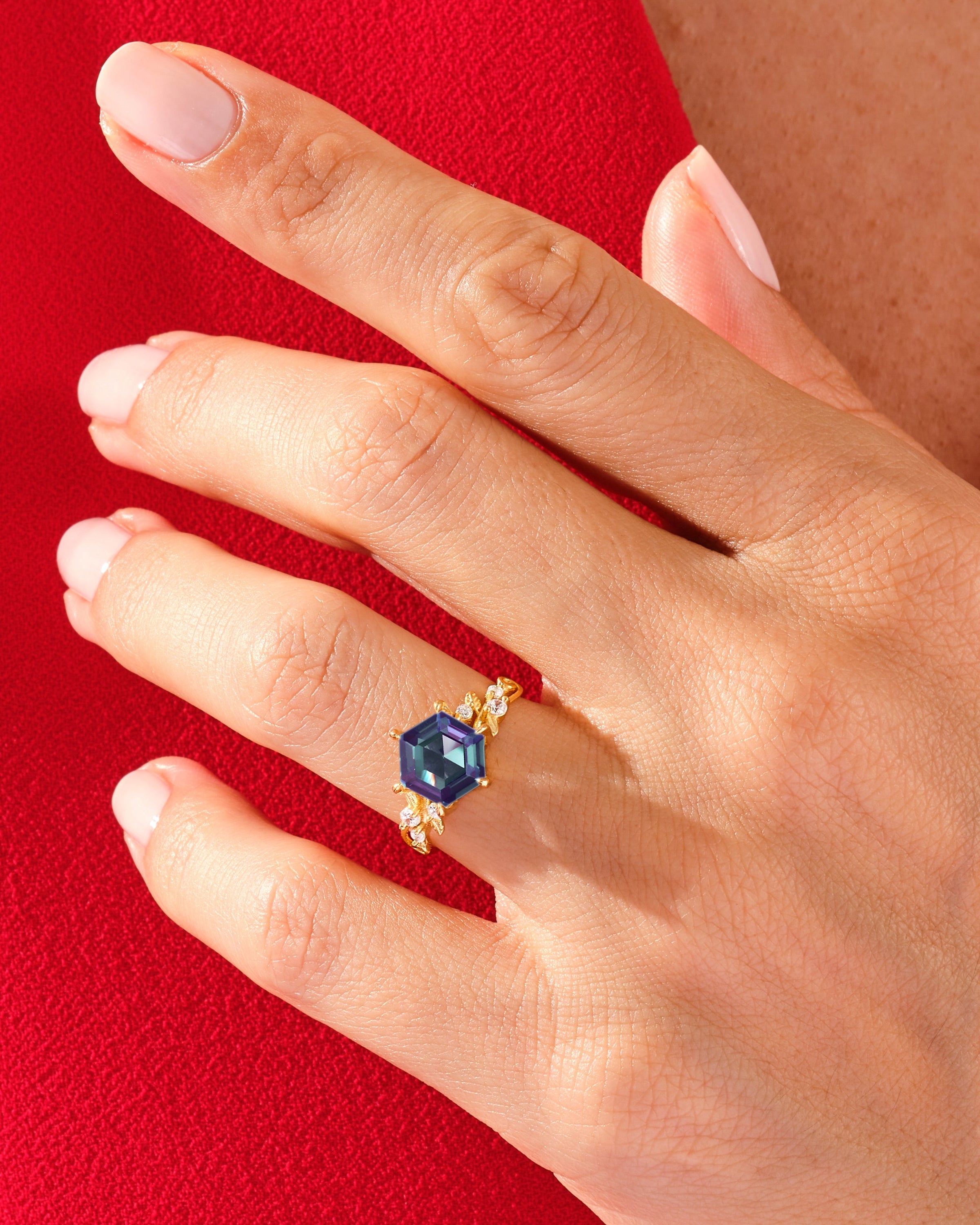 Gold ring with hexagon gemstone and diamonds on hand