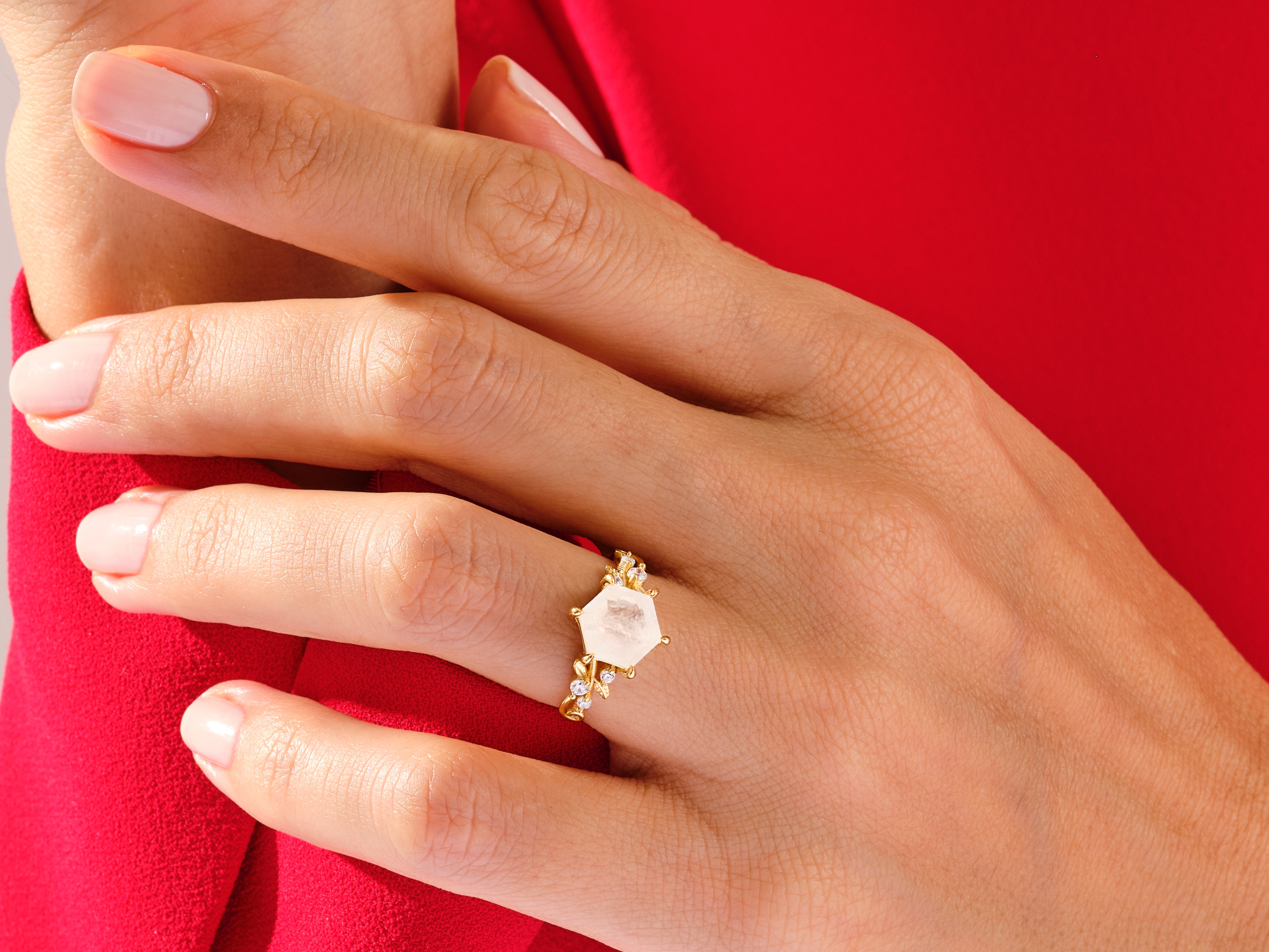 Gold ring with hexagon gemstone and diamonds on hand