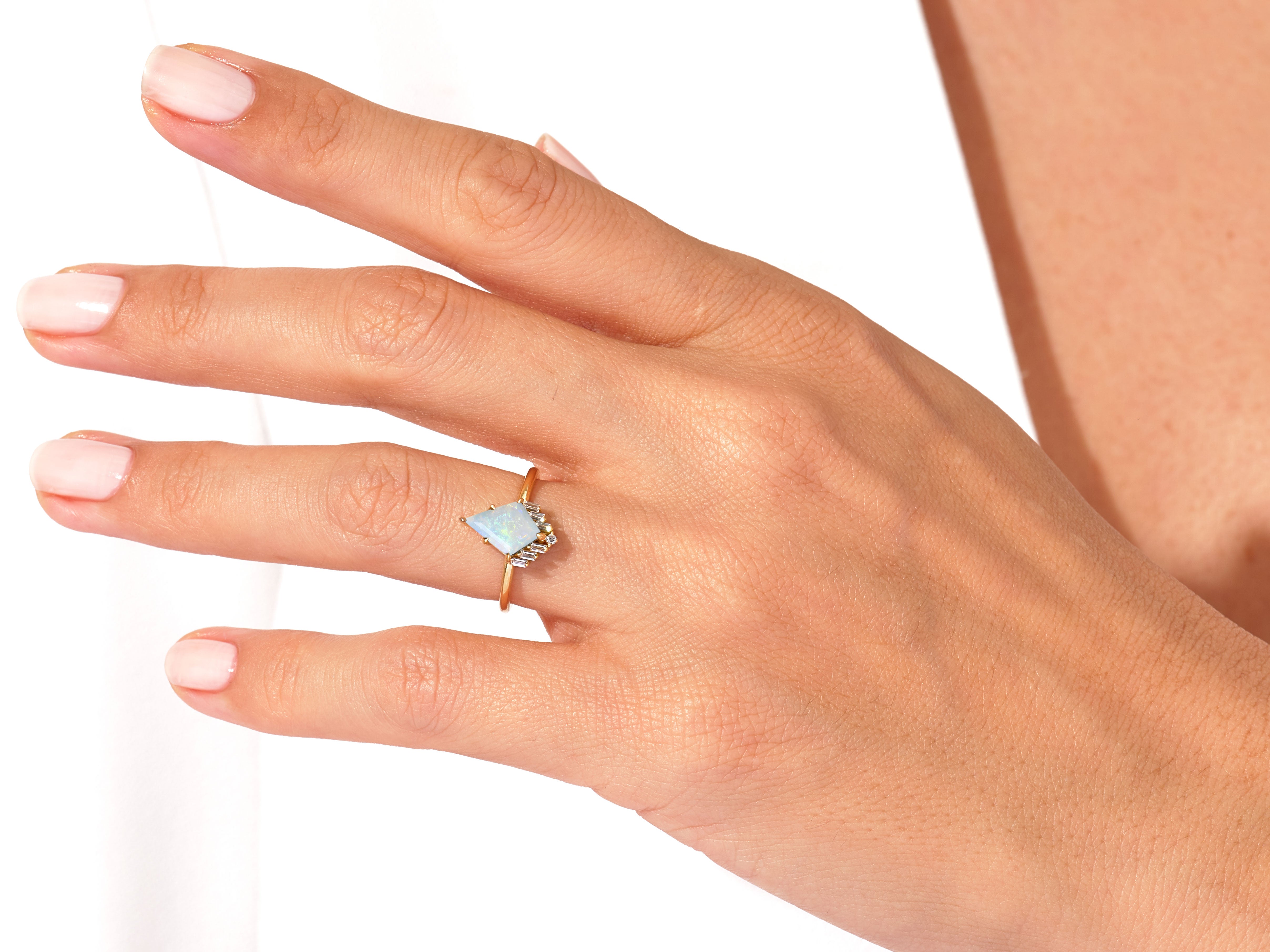 Opal and diamond ring on a hand