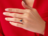 Gold ring with blue gemstone and diamonds on a hand