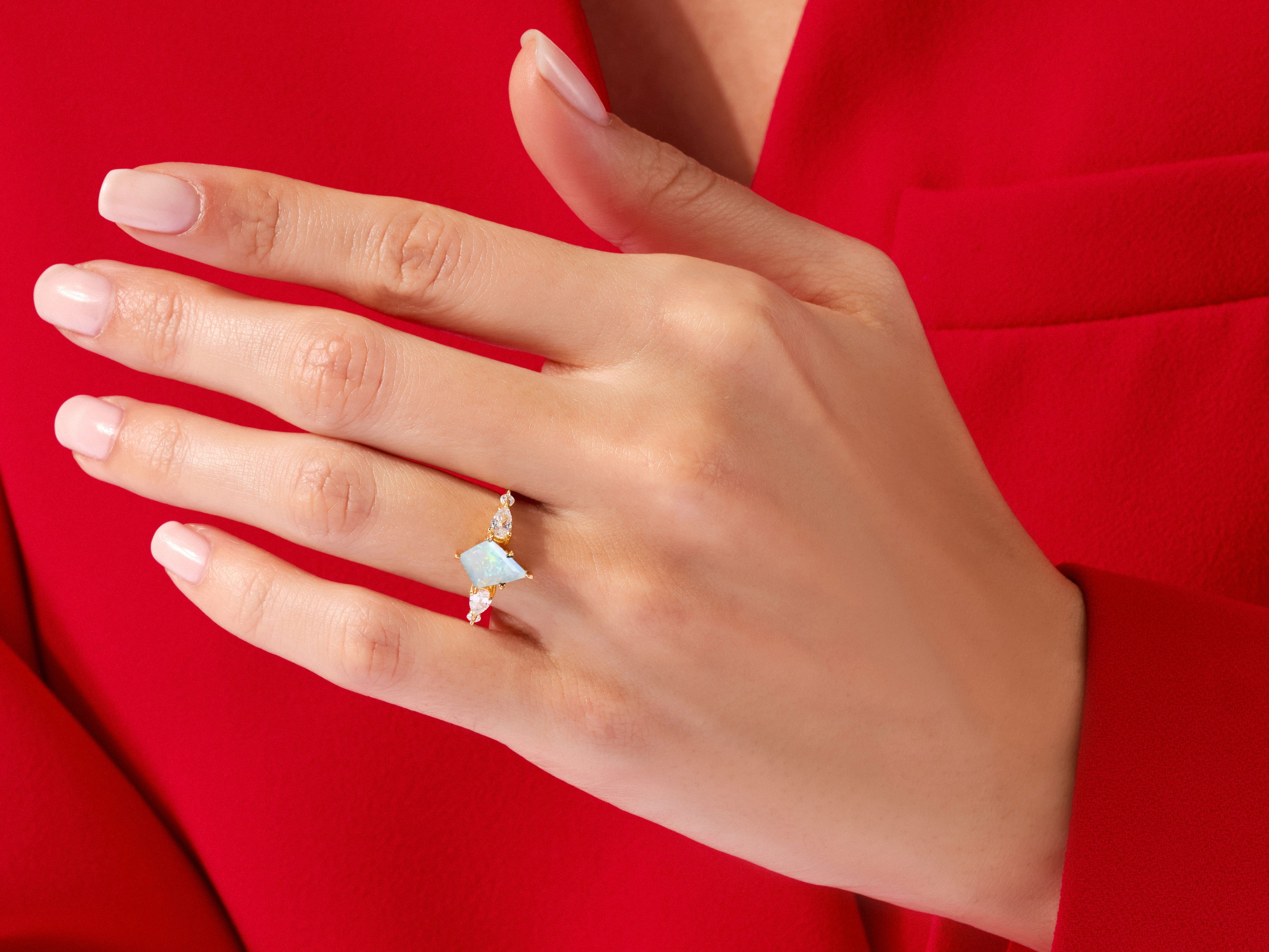 Gold opal ring with diamonds on a hand