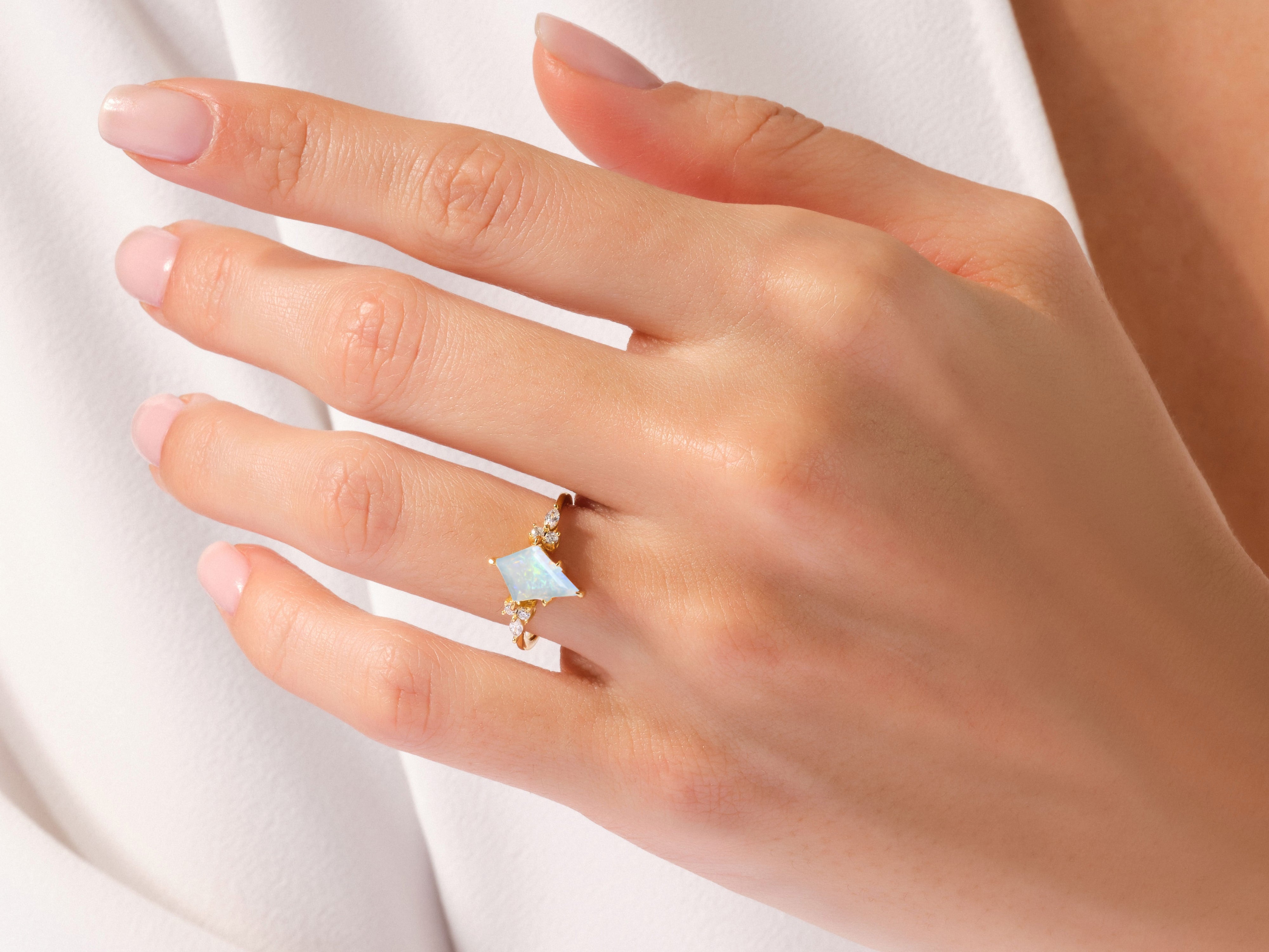 Gold ring with opal and diamonds on a woman's hand