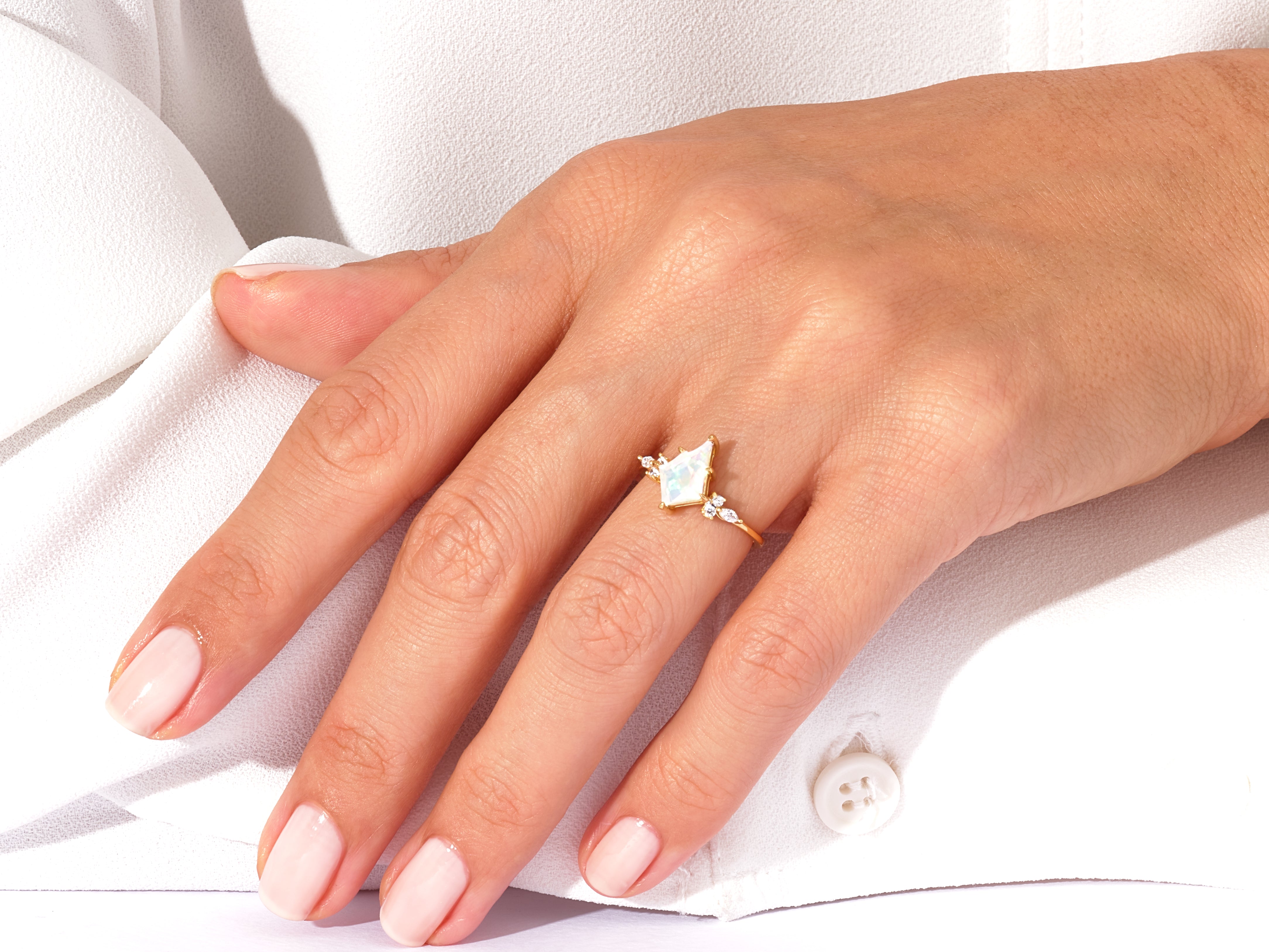Gold ring with opal and diamonds on a woman's hand