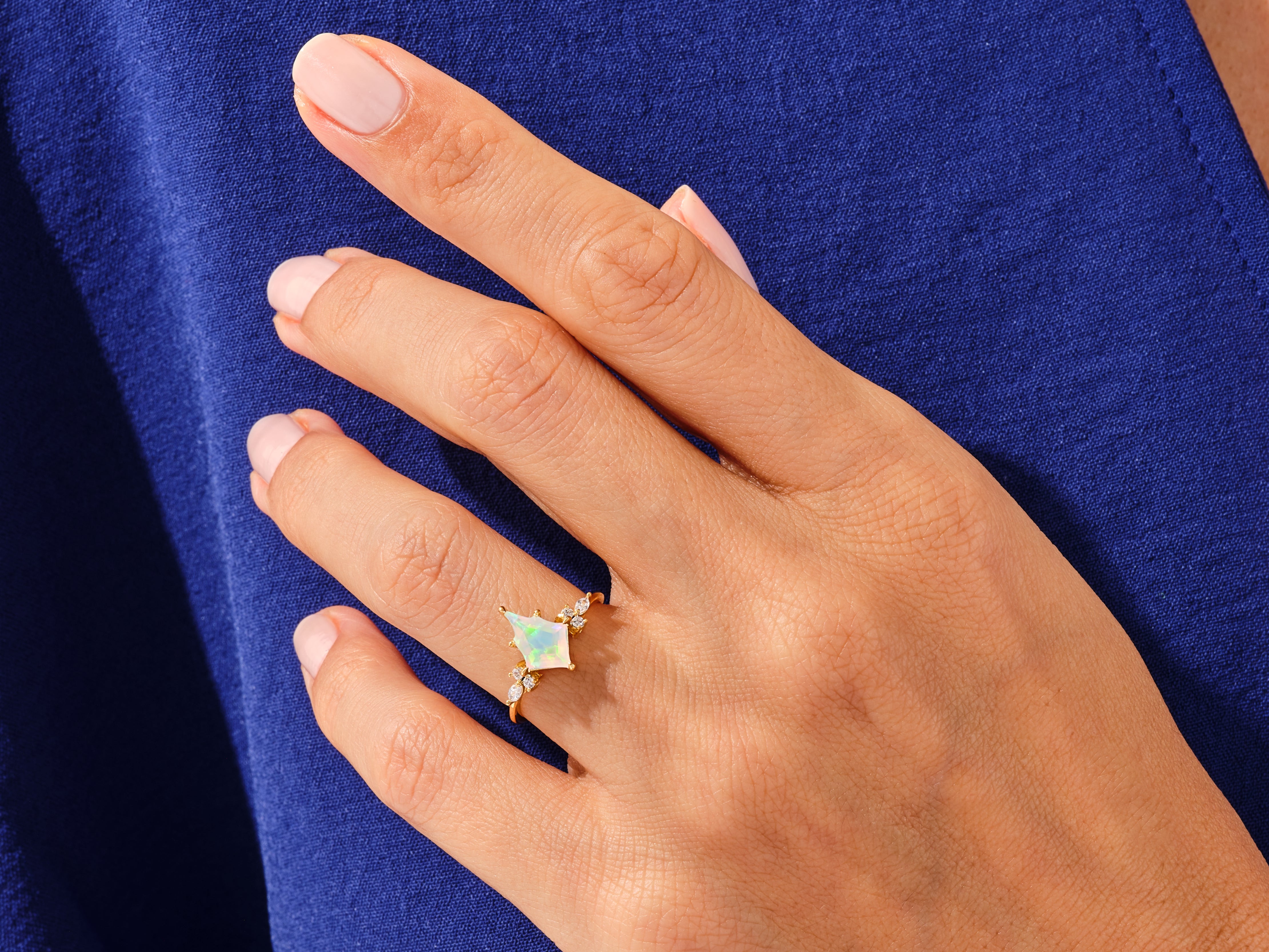 Gold ring with opal and diamonds on a woman's hand