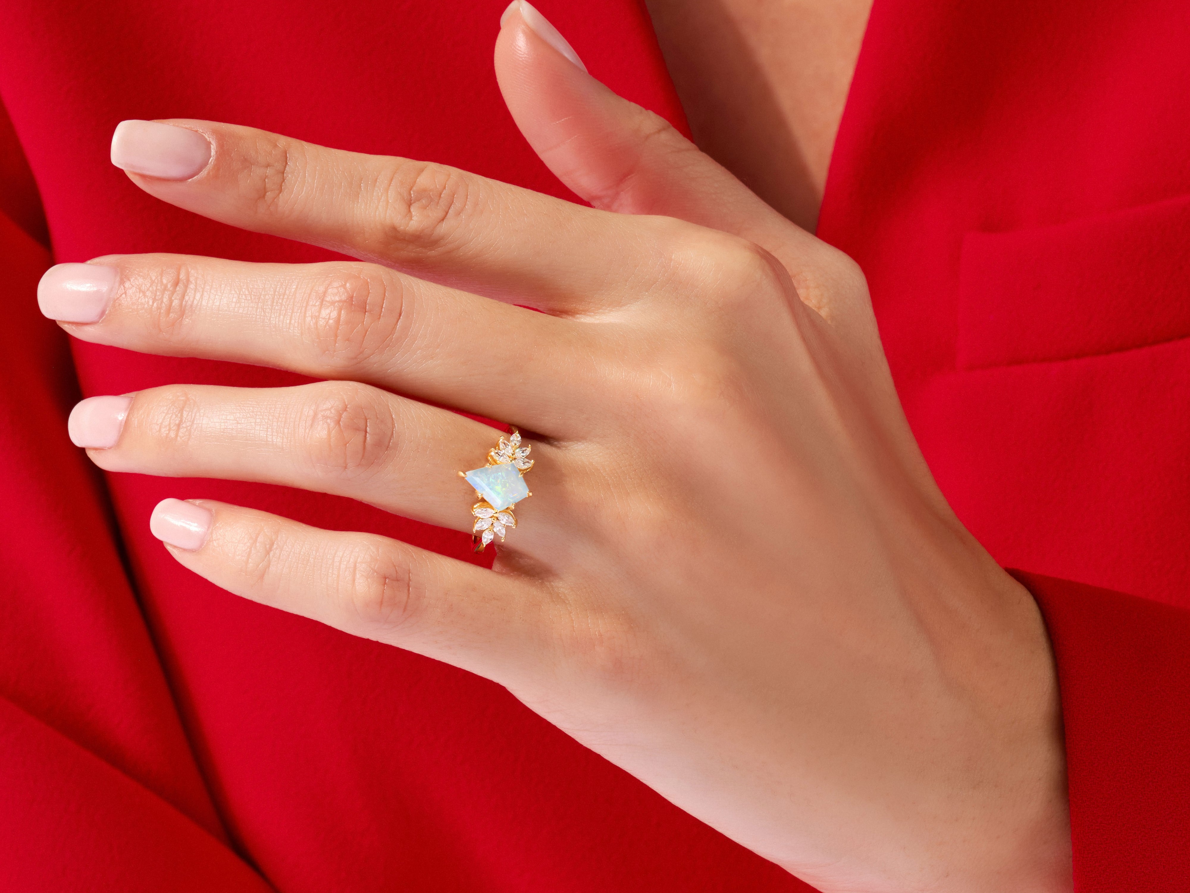 Gold opal ring with diamonds on a hand