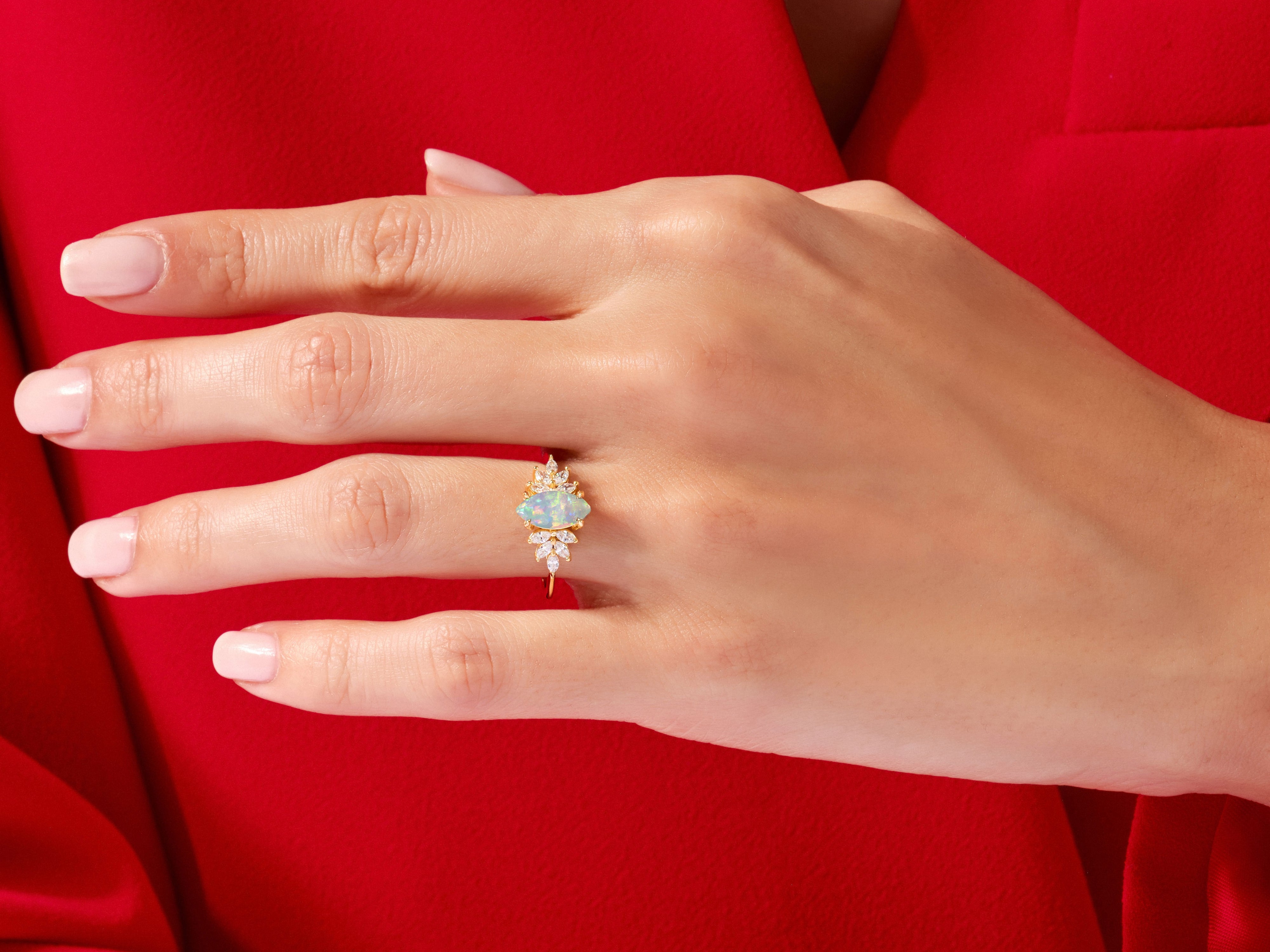 Gold opal and diamond engagement ring on a hand