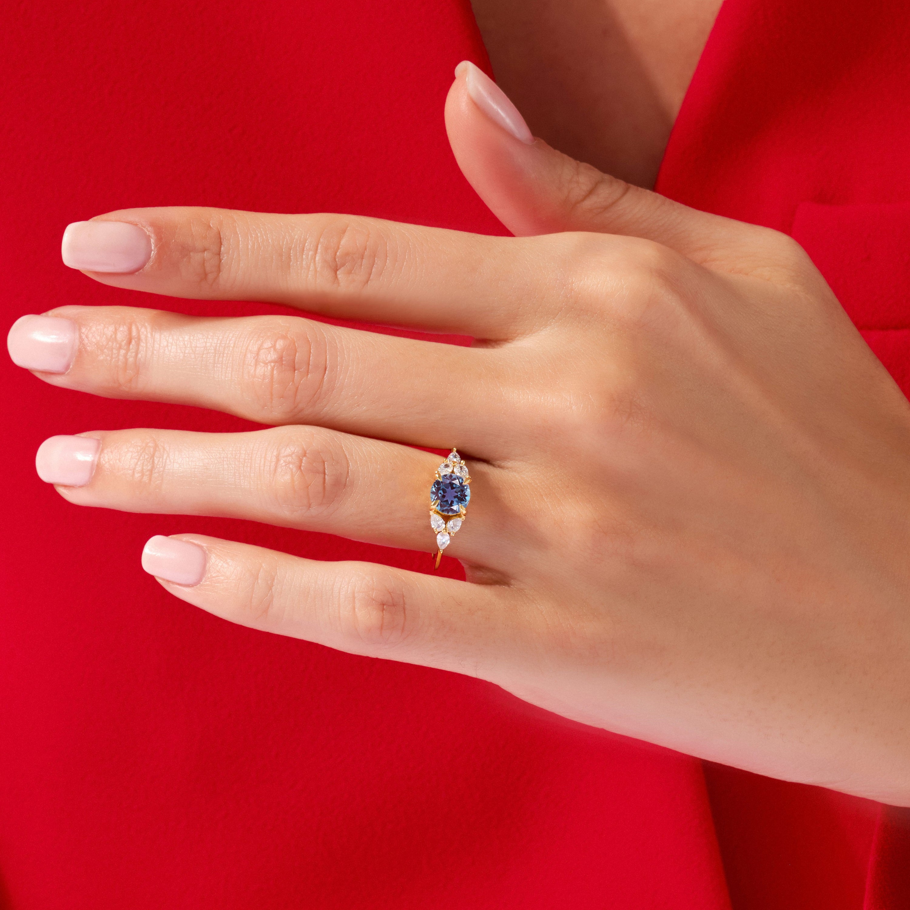 Gold ring with blue sapphire and diamonds on a hand