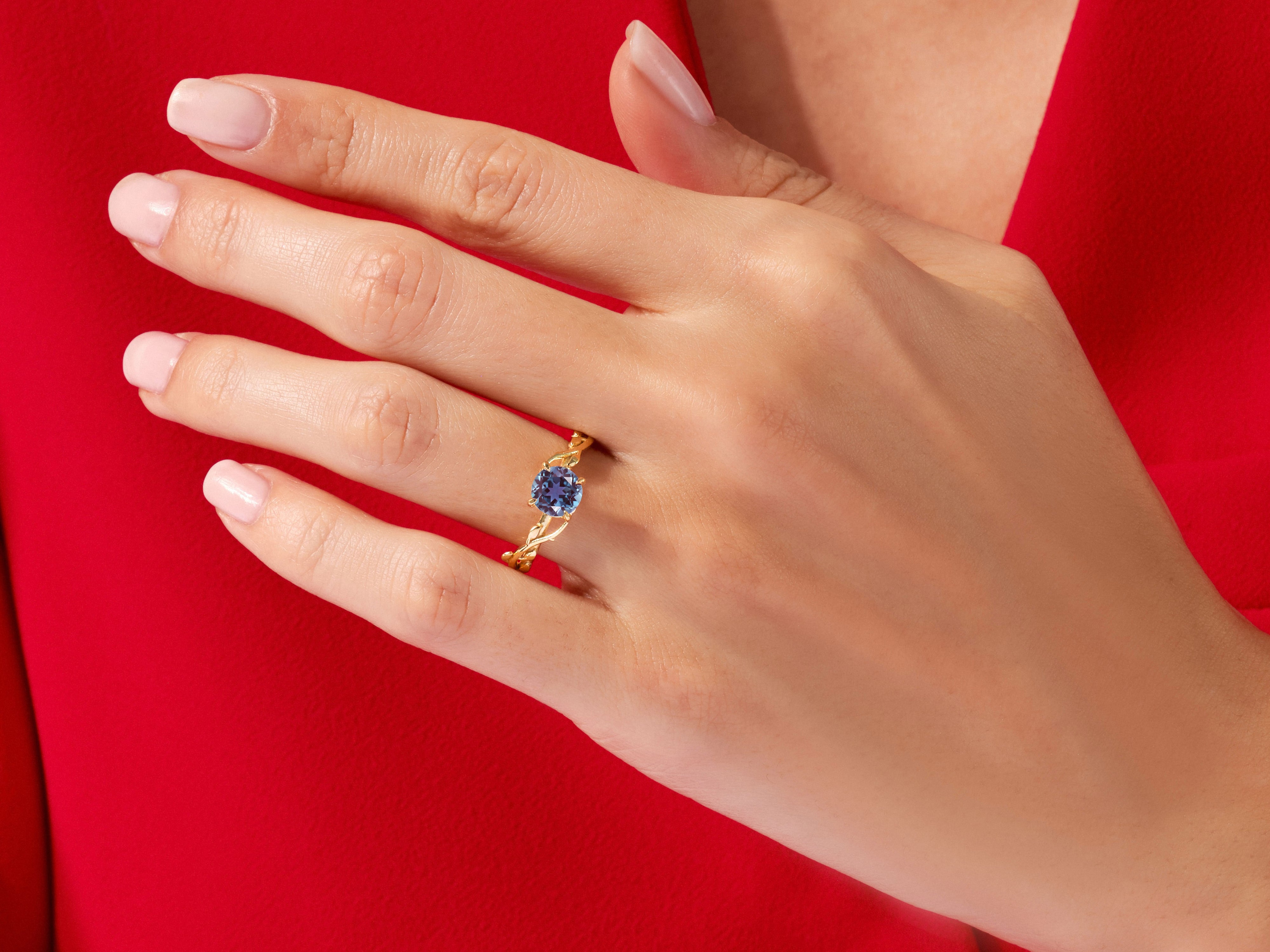 Gold ring with blue gemstone on hand, jewelry product